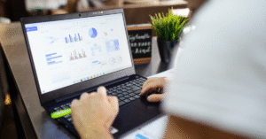 laptop on desk showing graphs
